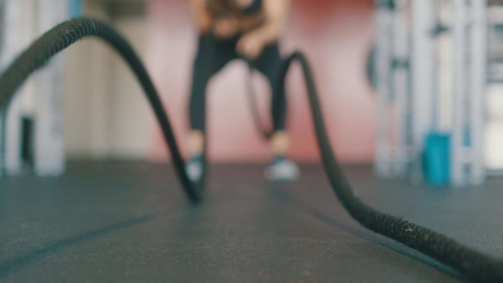 person holding black exercise rope and showing HIIT workout