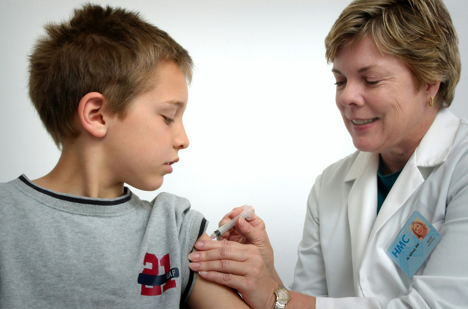 woman inject boy on arm to prevent influenza spread."