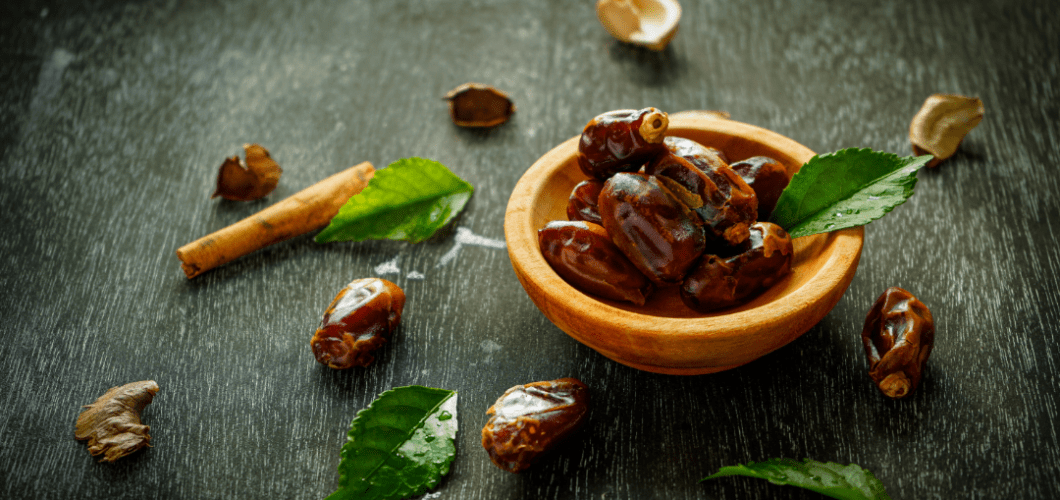 Close-up of fresh and dried dates side by side, showcasing their distinct textures and colors. Fresh dates are plump, moist, and lighter in color, while dried dates are darker, wrinkled, and chewy."